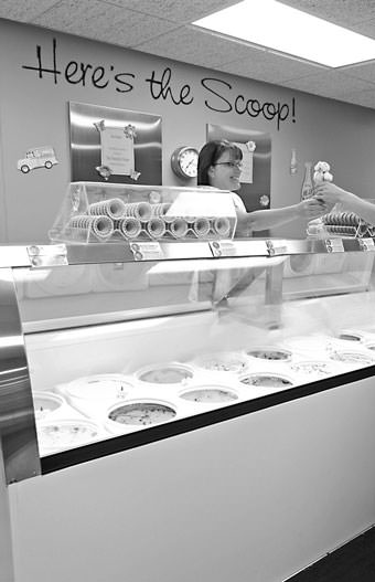 worker hands a customer an ice cream cone
