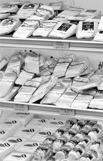 black and white photo of cheese products chilling on shelves
