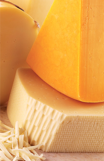blocks of cheese on wooden cutting board